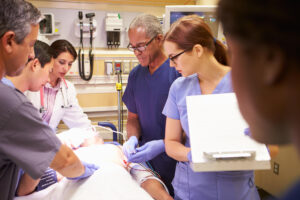 a color photo of an Emergency Department medical team around the bed of a patient in the Emergency Department