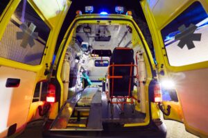 a full color photo of a mobile stroke unit ambulance with the rear doors open showing all the complex medical equipment inside