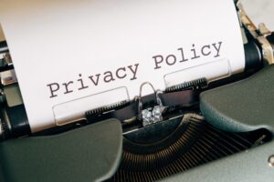 mockup photo of a sheet of paper in an older typewriter with the words "Privacy Policy" in huge letters