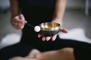 Tibetan singing bowl held by an out-of-focus young woman in a black yoga outfit - Image by Binja69