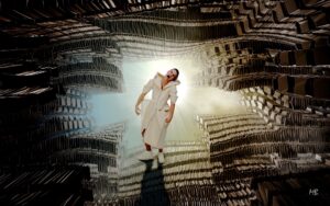 A woman stands in a bizarre space filled with tens of thousands of what looks like file folders. She's in an odd white garment and is screaming, hands clenched. There's a brilliant white light behind her. The whole scene is grotesque and unworldly.